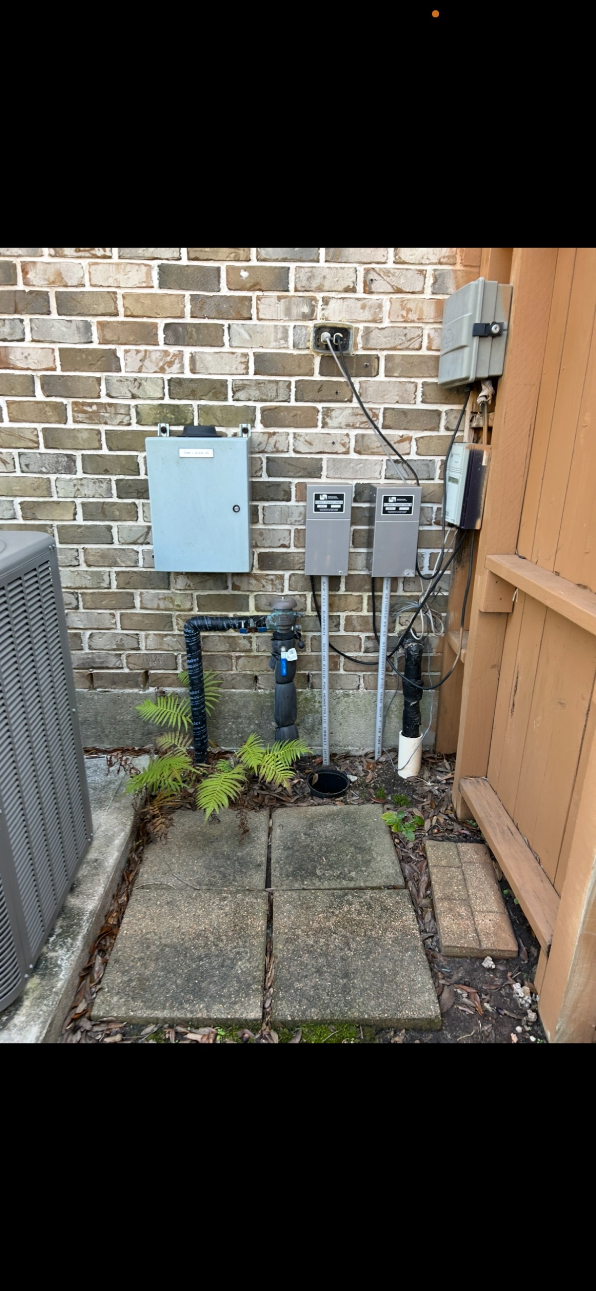 Before: exterior wall with pipes but no water softener installed
